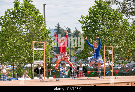 Ces deux jeunes filles de l'adolescence sont la danse style écossais avec des jupes de plaid et robe écossaise traditionnelle. Banque D'Images