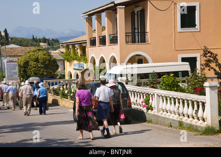 Les touristes marcher dans la rue à Kassiopi sur la Méditerranée grecque de Corfou Grèce GR Banque D'Images