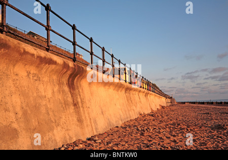 Mur de la mer et des cabines de plage à Mundesley, Norfolk, Angleterre, Royaume-Uni, tôt le matin, la lumière. Banque D'Images