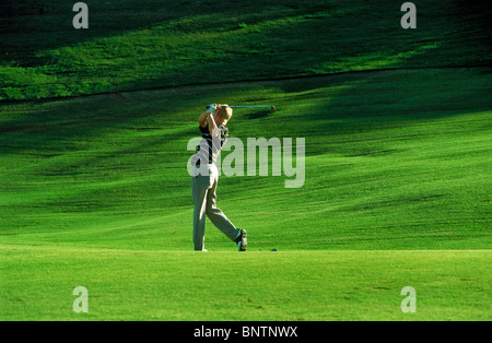 Male golfer hitting fairway au milieu de la mer de vert Banque D'Images