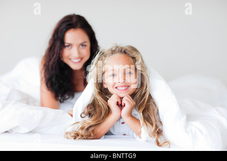 Mère et fille heureux s'amusant on bed Banque D'Images