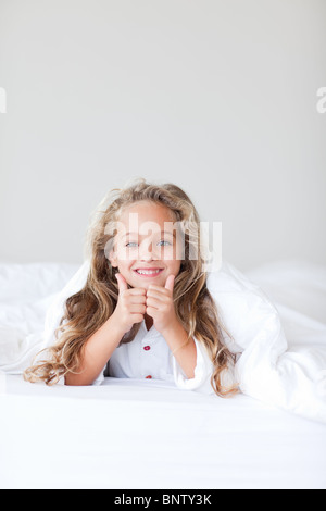 Portrait of a cute girl lying on a bed Banque D'Images
