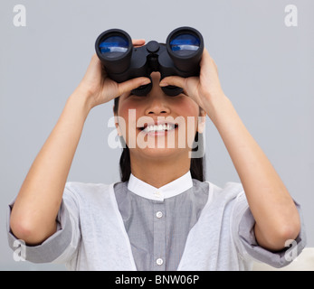 Visionary businesswoman looking through binoculars Banque D'Images