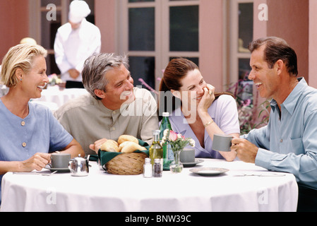 Deux couples en train de dîner ensemble à la terrasse de restaurant Banque D'Images