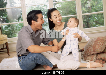 Heureux parents assis avec leur fils nouveau-né Banque D'Images