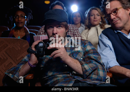 L'homme à l'aide d'enregistreur vidéo dans movie theatre Banque D'Images