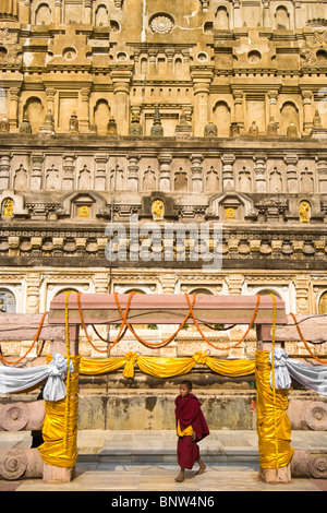 Un moine novice promenades à travers une arche au temple de la Mahabodhi à Bodhgaya en Inde Banque D'Images