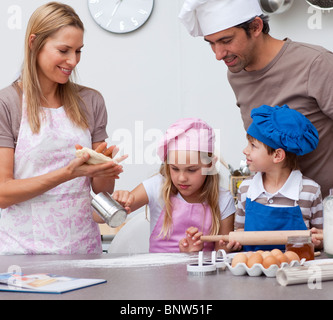 Mère et père d'aider les enfants à la cuisson dans la cuisine Banque D'Images