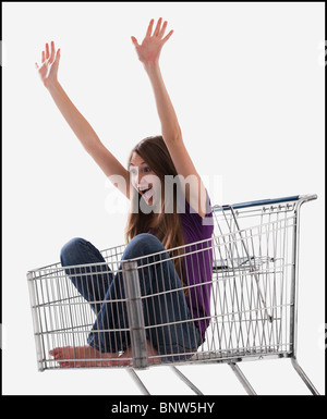 Excited woman sitting in a shopping cart Banque D'Images