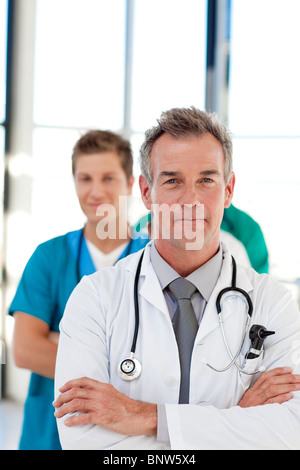 Friendly mature doctor menant son équipe Banque D'Images