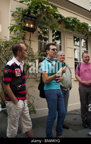 Groupe de touristes adultes prenant Gay History Tour du Paris des années 1980 par Guide, Hervé (aka La Taulière Tapie). Quartier du Marais, Banque D'Images