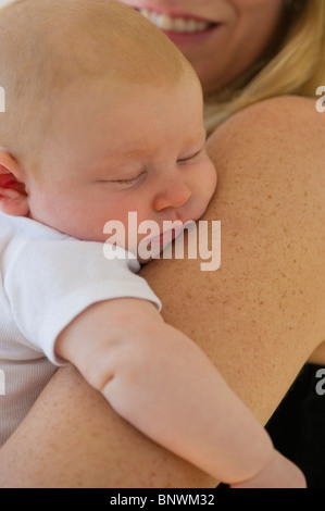 Baby sleeping in mother's arms Banque D'Images