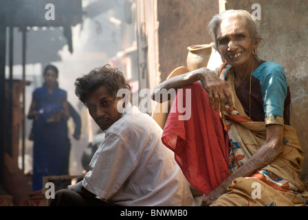 Homme et femme regardant la caméra, Kumbharwada, Dharavi, Mumbai, Inde Banque D'Images