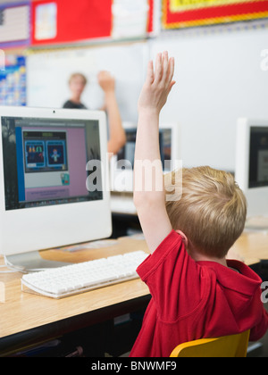 Student raising hand in classroom Banque D'Images