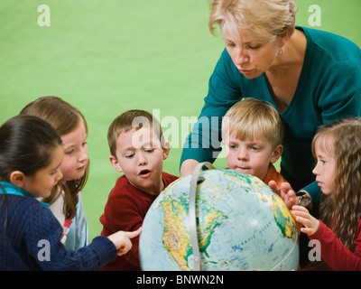 Montrant l'enseignant de maternelle à globe Banque D'Images