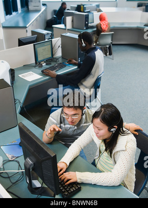 Les étudiants adultes qui travaillent sur des ordinateurs à un centre d'apprentissage Banque D'Images