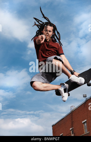 Teenage boy faire skateboard jump Banque D'Images