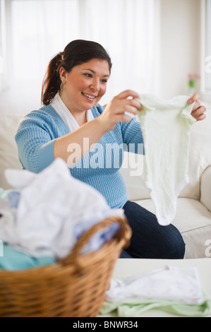L'excès de woman folding clothes Banque D'Images