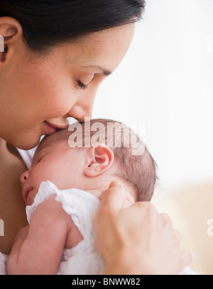 Mère embrassant la tête de bébé Banque D'Images