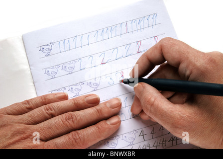 La main de l'enseignant avec stylo rouge la révision des devoirs Banque D'Images