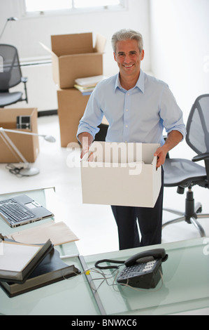 Businessman holding a fort dans son nouveau bureau Banque D'Images