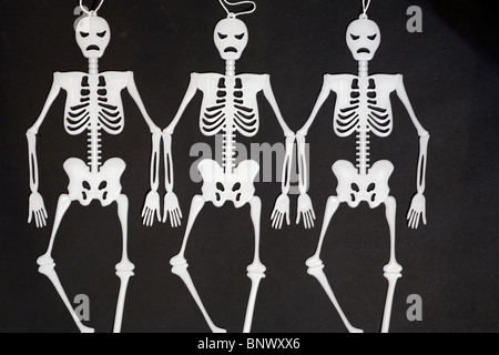 Trois squelettes suspendus dans la penderie - squelettes dansant sur fond noir - concept d'anorexiques skinny mince Banque D'Images