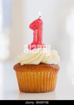 Bougie allumée sur cupcake pour premier anniversaire célébration Banque D'Images