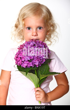 Jolie petite fille avec une fleur dans sa main Banque D'Images