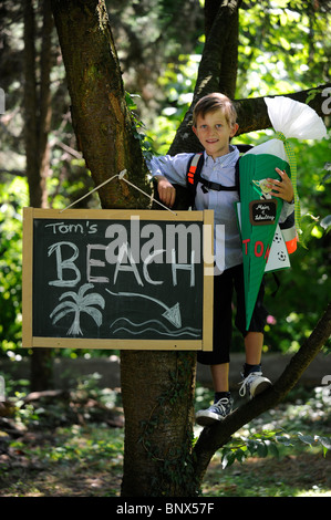 Première journée à l'école. Garçon avec cône en carton dans la cour de l'école. Banque D'Images