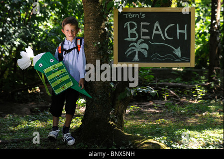 Première journée à l'école. Garçon avec cône en carton dans la cour de l'école. Banque D'Images
