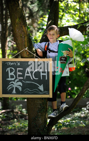 Première journée à l'école. Garçon avec cône en carton dans la cour de l'école. Banque D'Images
