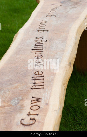 Banc de jardin en bois sculpté avec le mot 'poussent de petites plantules grandissent grandissent' à Harlow Carr de l'ERS Banque D'Images