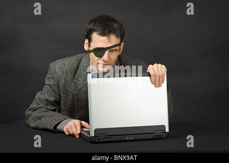 L'ordinateur pirate regardez avec un œil sur fond sombre Banque D'Images