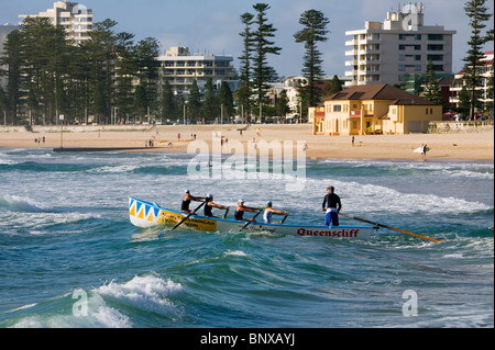 Une équipe de surfboat lignes dans les vagues à Manly Beach. Sydney, New South Wales, Australia Banque D'Images