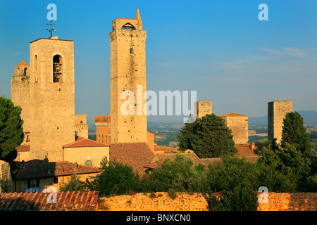 L'emblématique tours médiévales dans la colline de la ville Toscane San Gimignano, Italie, illuminée par le soleil couchant Banque D'Images