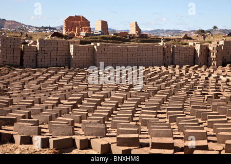 La fabrication de briques à partir de la vase de rizières dans les hautes terres centrales de Madagascar. Le four en briques est dans l'arrière-plan. Banque D'Images