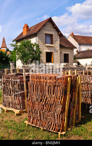 Pile de recyclage de vieux toits d'argile rouge en face de maison modernisée - France. Banque D'Images