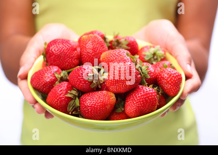 De la vaisselle avec des fraises en femme mains. Banque D'Images