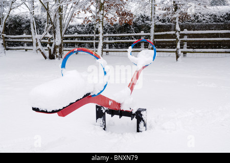 Une aire de jeux pour enfants du village sous une couverture de neige. Wrington, Somerset, Angleterre. Banque D'Images