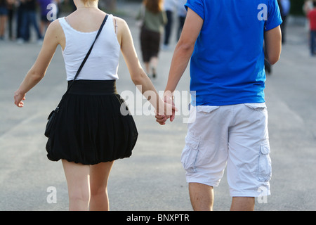 Un couple de deux jeunes milieux laissant les mains. street scène d'amour. Banque D'Images