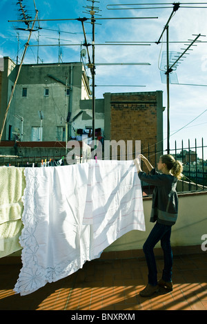 Teenage girl étendre le linge à sécher sur le toit des vêtements Banque D'Images