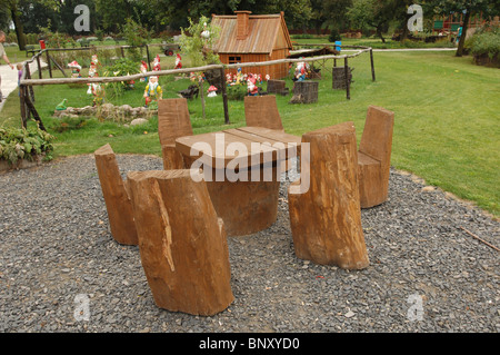 Une table de pique-nique dans un parc de Nowa Sol, la Pologne avec un tableau des nains de jardin sur l'affichage à l'arrière-plan. Banque D'Images