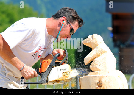 Démonstration de sculpture sur bois à la tronçonneuse, l'homme sculpte un animal figure à partir de bois avec une scie à chaîne Banque D'Images