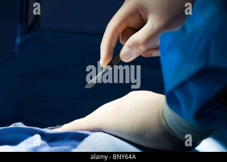 Chirurgien de commencer la procédure avec un scalpel à la main, close-up Banque D'Images