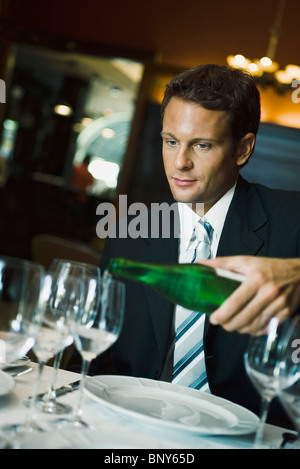 Au restaurant de l'homme regardant waiter verse vin Banque D'Images