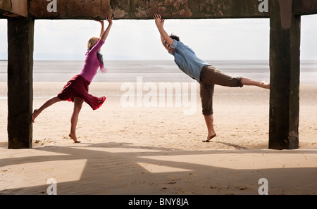 Couple exercising on beach Banque D'Images