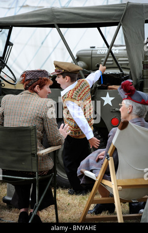 Un garçon semble s'ennuyer dans une section à thème nous de la bataille d'Angleterre village au Royal International Air Tattoo à Salon de la RAF Banque D'Images