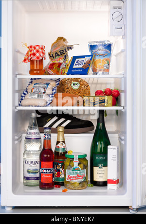 Divers produits alimentaires et d'une chaussure de sport dans un réfrigérateur, Berlin, Allemagne Banque D'Images