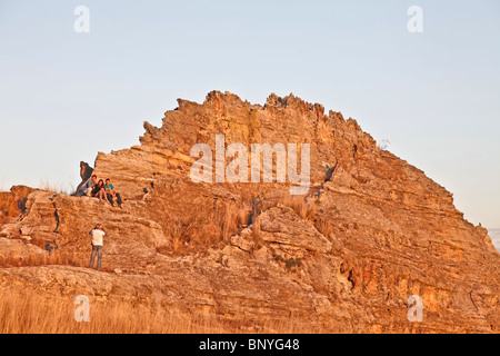 L'homme de prendre une photo d'un groupe de personnes contre un massif sandtone au coucher du soleil près de la fenêtre de l'Isalo National Park, au sud-ouest de Madagascar Banque D'Images