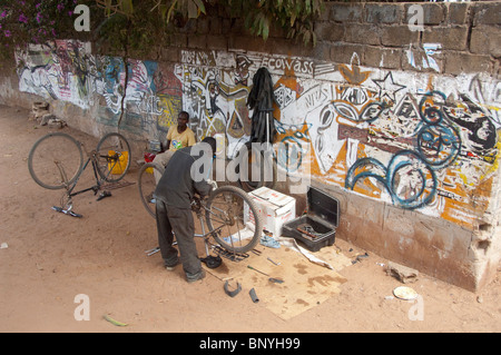 L'Afrique, Gambie. Capitale de Banjul. Scène de rue de la vie quotidienne, l'atelier de réparation de vélos locaux. Banque D'Images